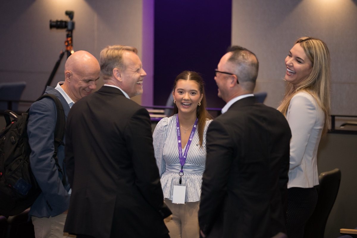 A small group of founders and executives laughing together in conversation at a Founders Arena event.